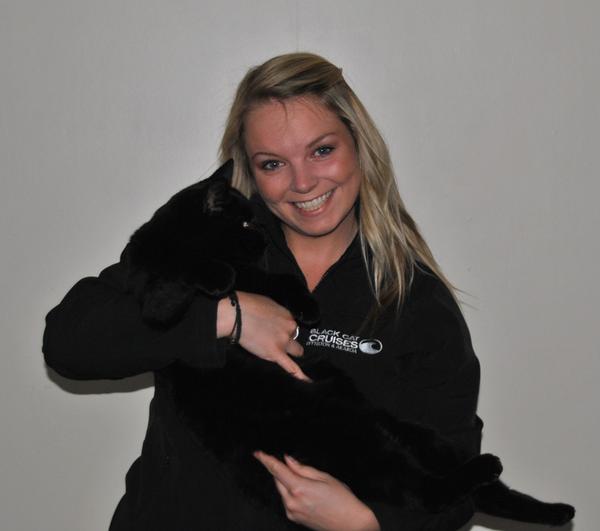 Black Cat customer services staff member Jodie Oliver gets up close and personal with a black cat